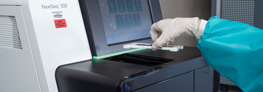 Scientist holding tray over machine