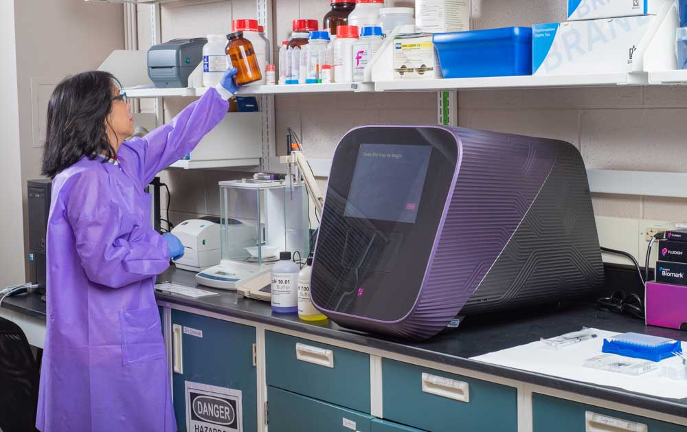 Scientist reaching for bottle