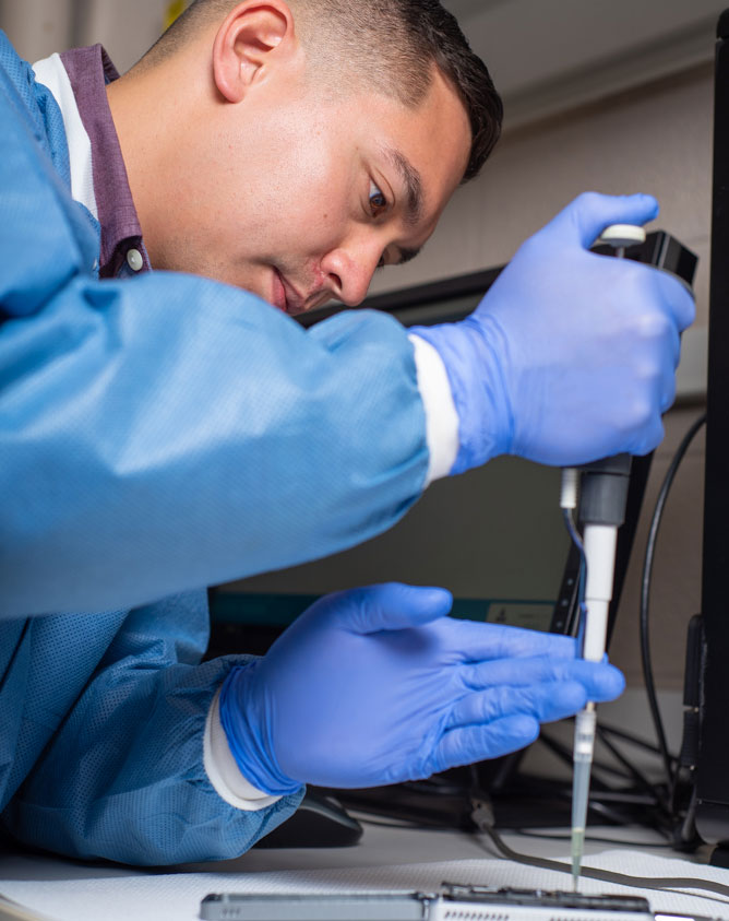 Scientist injecting liquid into machine