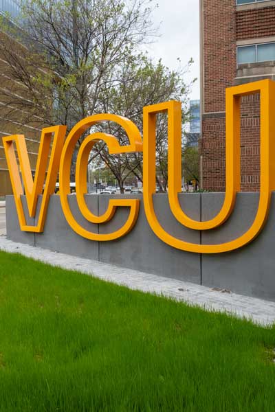 a large sign among tall downtown buildings with the letters v, c, u